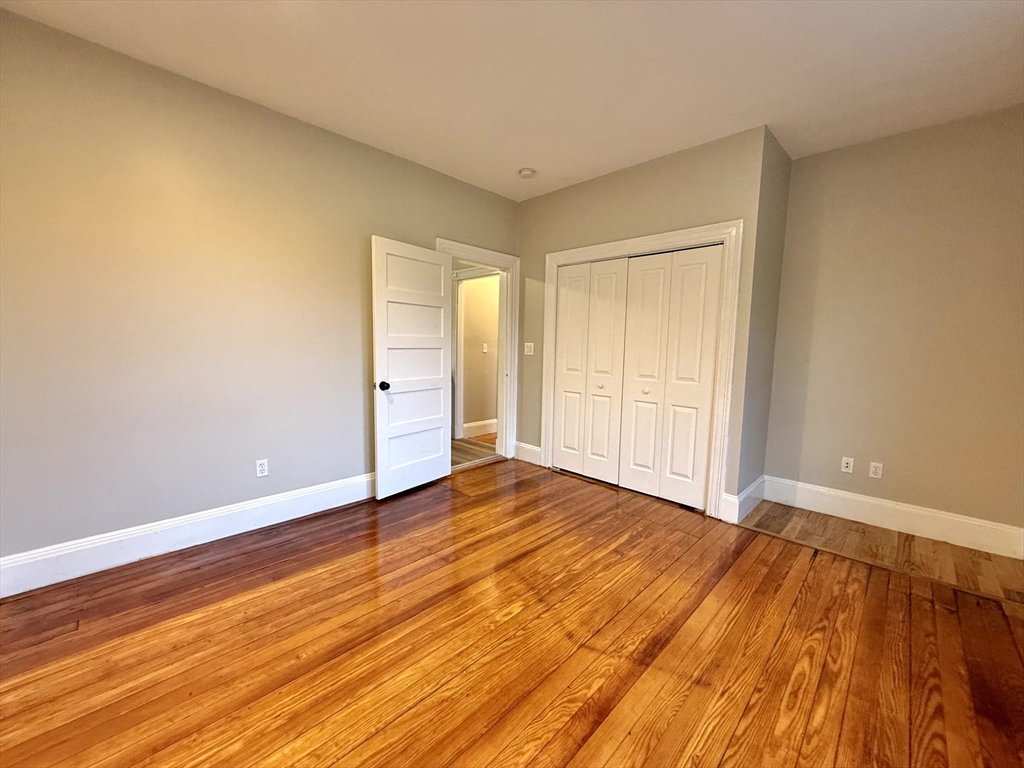 89 Grove Street, Unit 89 Belmont, MA 02478 - Photo 12 of 27 a view of an empty room with wooden floor