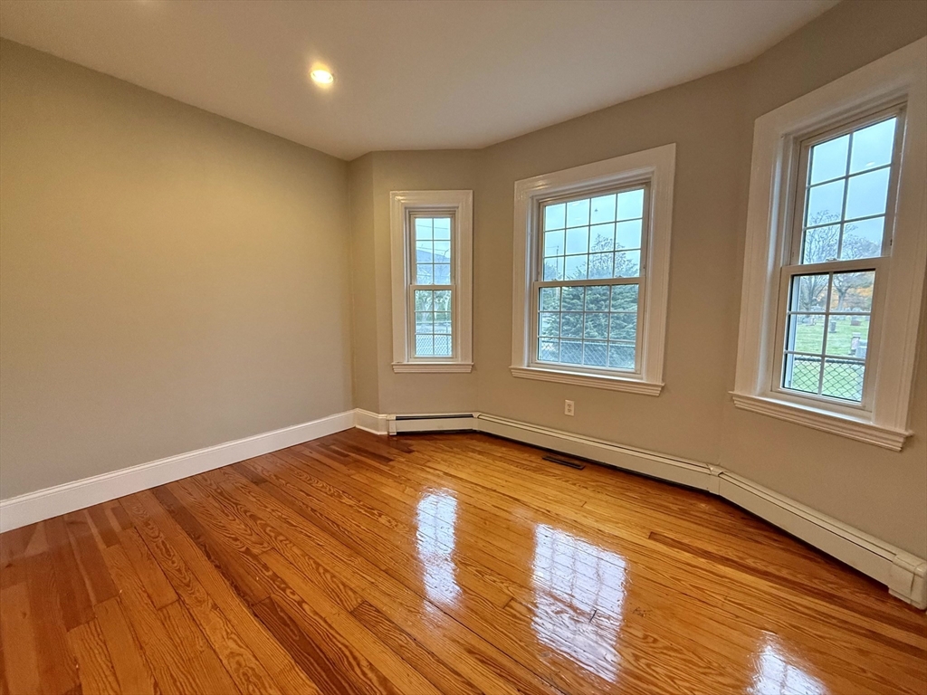 89 Grove Street, Unit 89 Belmont, MA 02478 - Photo 14 of 27 a view of an empty room with window and wooden floor