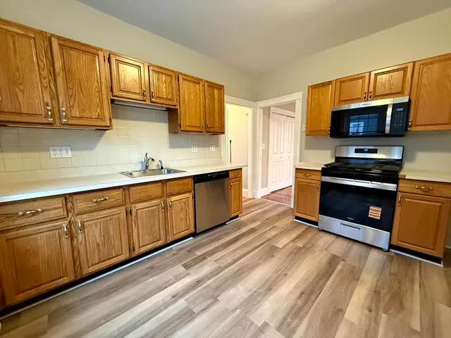 a kitchen with stainless steel appliances granite countertop a stove a sink and a microwave