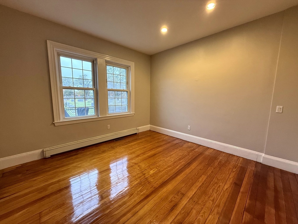 89 Grove Street, Unit 89 Belmont, MA 02478 - Photo 10 of 27 a view of an empty room with wooden floor and a window