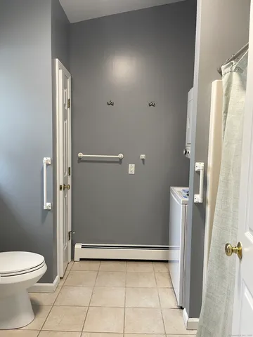 a bathroom with a toilet a window and shower