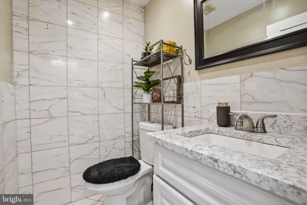 a view of a hallway with a refrigerator and a fireplace