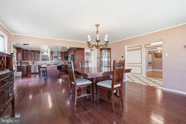 a kitchen with stainless steel appliances granite countertop wooden floors wooden cabinets a sink and a window