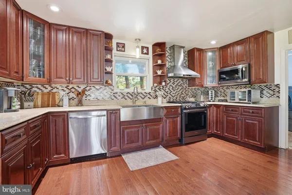 a kitchen with stainless steel appliances wooden floor dining table and chairs
