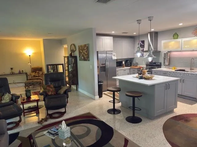 a kitchen with sink refrigerator dining table and chairs