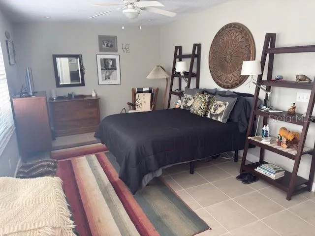 a bedroom with a bed a mirror and lamp on desk