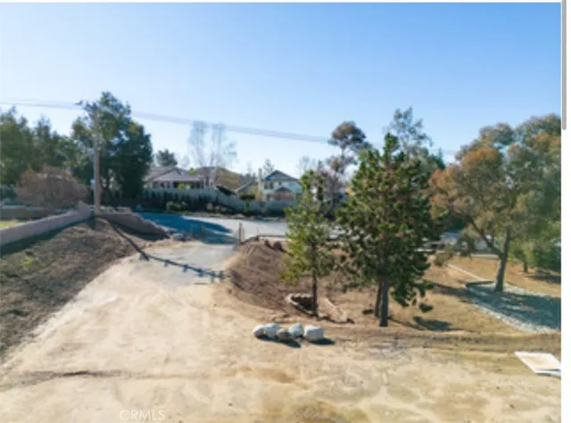 a view of a dry yard with wooden fence