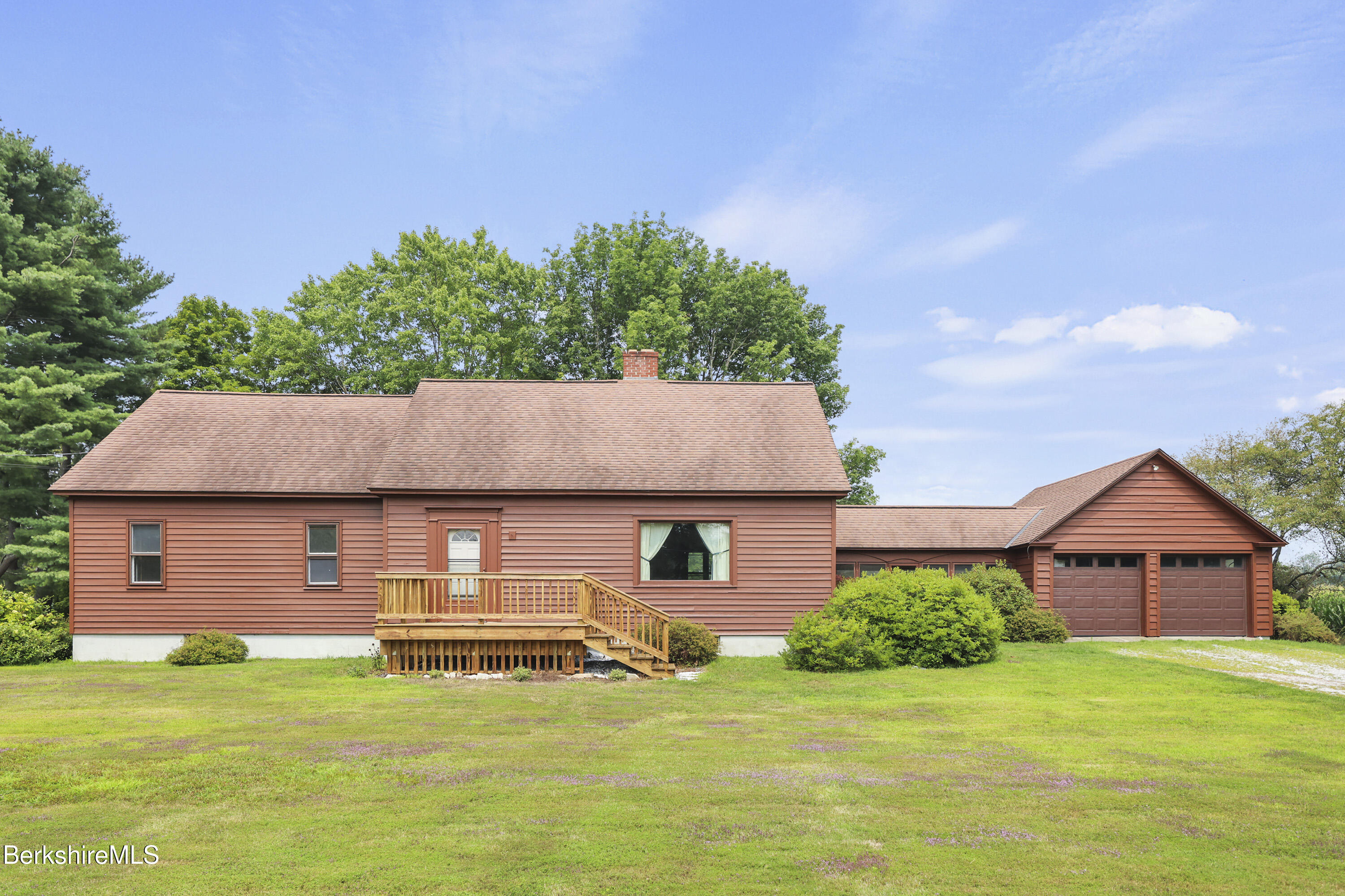 a front view of a house with a garden and deck