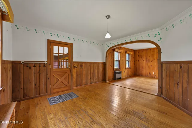 a view of a livingroom with wooden floor fireplace and a window