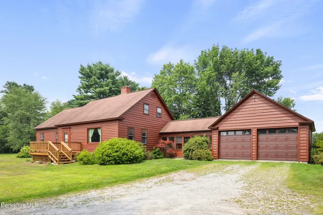 a front view of a house with a garden and yard