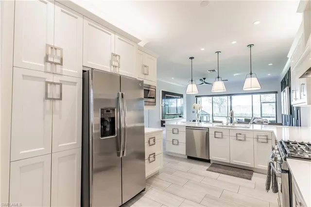 a kitchen with stainless steel appliances kitchen island granite countertop a refrigerator and a stove top oven