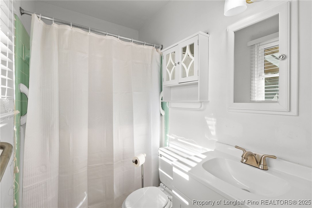 5123 Chesapeake Road Fayetteville, NC 28311 - Photo 16 of 24 a bathroom with a shower curtain and a sink