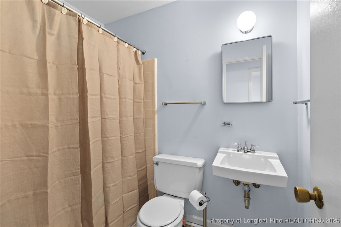 5123 Chesapeake Road Fayetteville, NC 28311 - Photo 19 of 24 a bathroom with a sink toilet and mirror