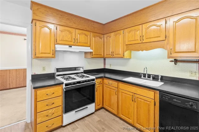 a kitchen with stainless steel appliances granite countertop a sink a stove and cabinets