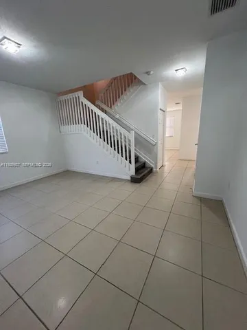 a view of an empty room and staircase