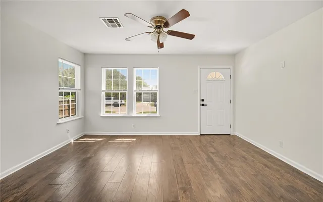 wooden floor in an empty room with a window