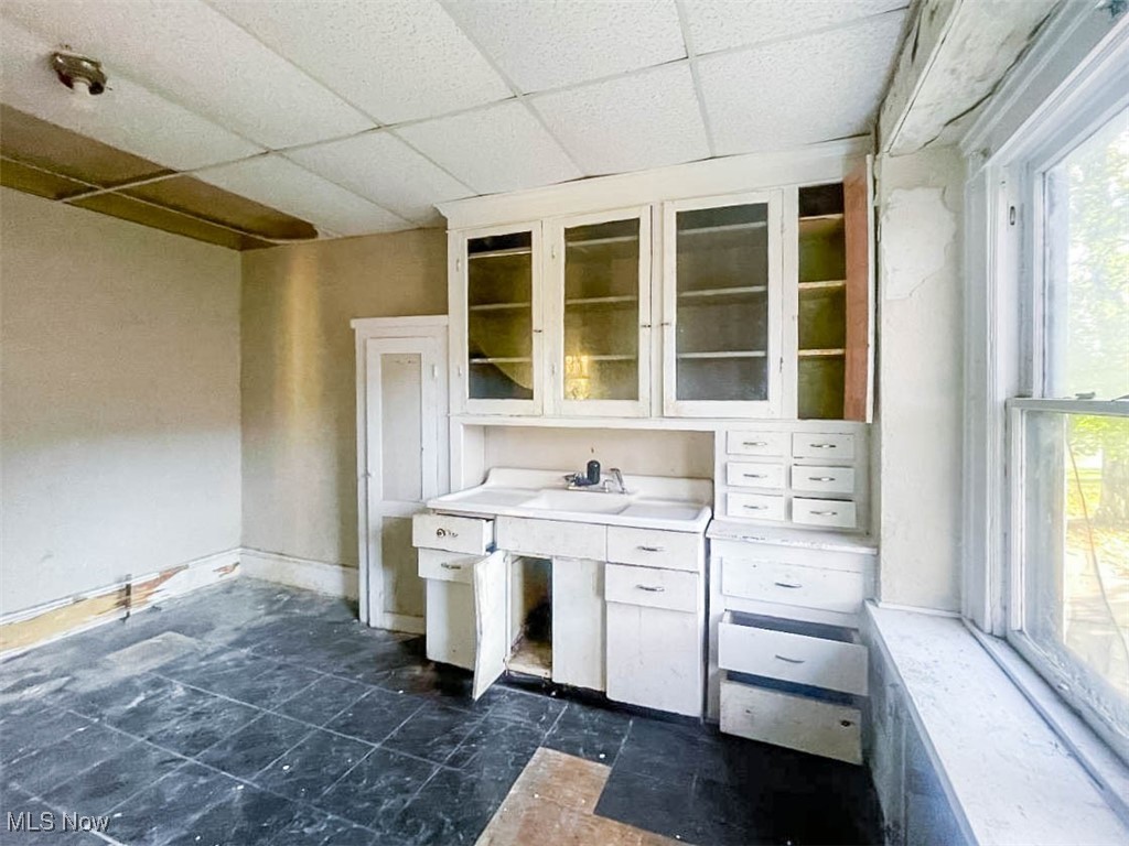 4730 Turney Road Cleveland, OH 44125 - Photo 11 of 32 Kitchen featuring a drop ceiling, white cabinets, and sink