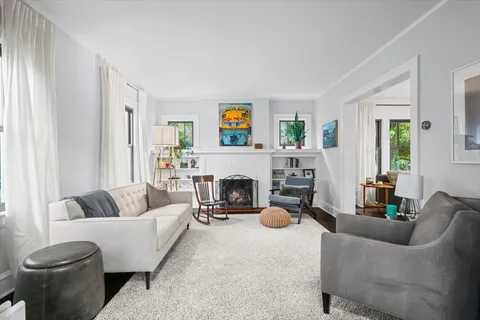 a living room with furniture a fireplace and a window