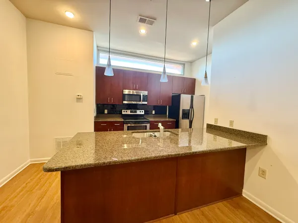 a kitchen with stainless steel appliances granite countertop a sink a stove and a refrigerator