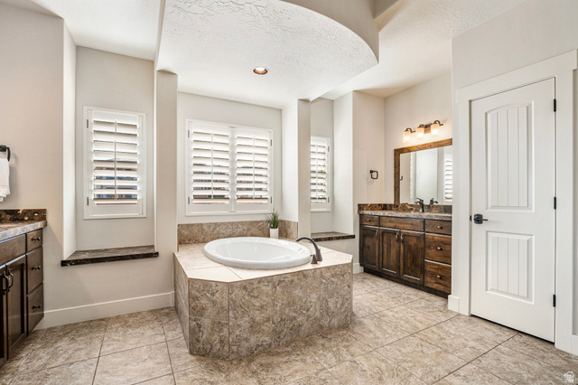 2311 South 1340 West St. George, UT 84770 - Photo 32 of 56 Bathroom featuring a bath, vanity, and a textured ceiling