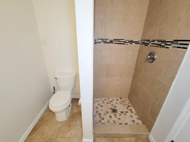 a bathroom with a toilet and a shower
