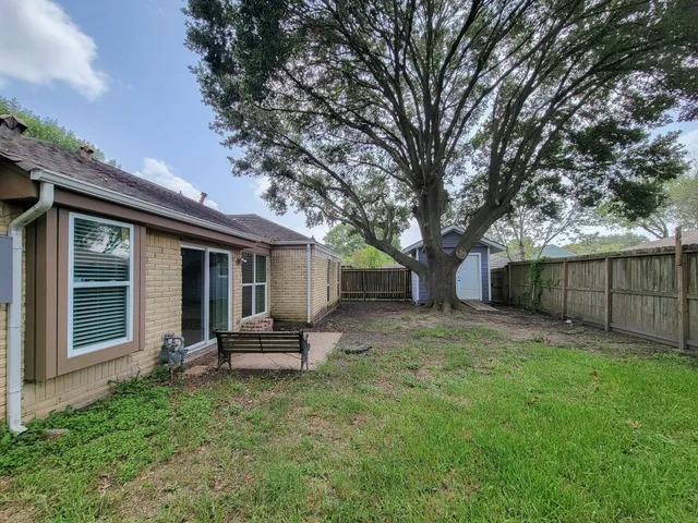 a backyard of a house with table and chairs
