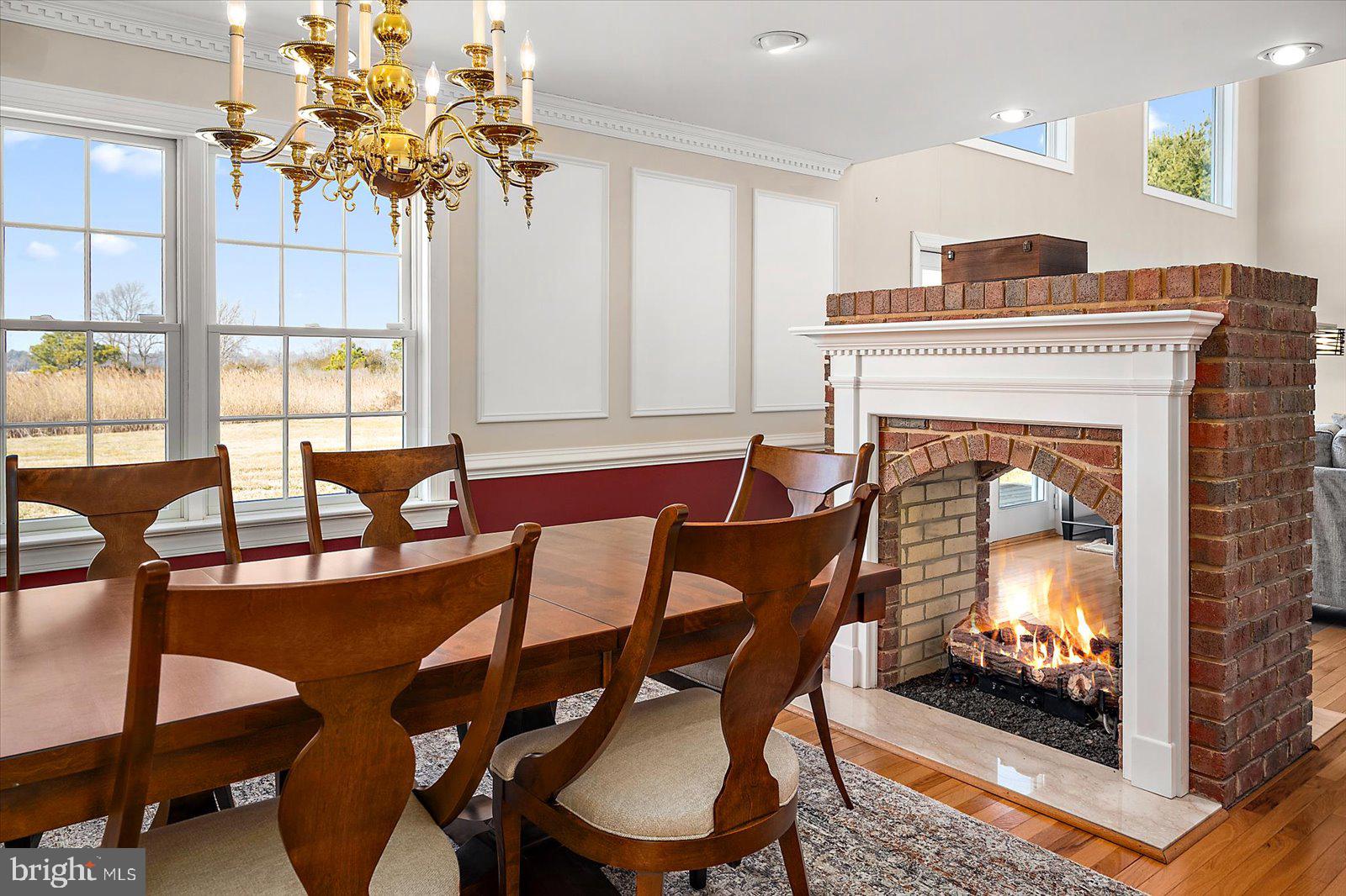 12661 Mallard Landing Road Princess Anne, MD 21853 - Photo 39 of 123 a dining room with furniture a fireplace and wooden floor