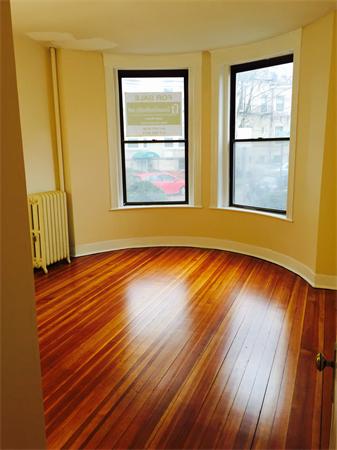 46 Orkney Road, Unit 1 Boston, MA 02135 - Photo 3 of 12 a view of an empty room with wooden floor and a window