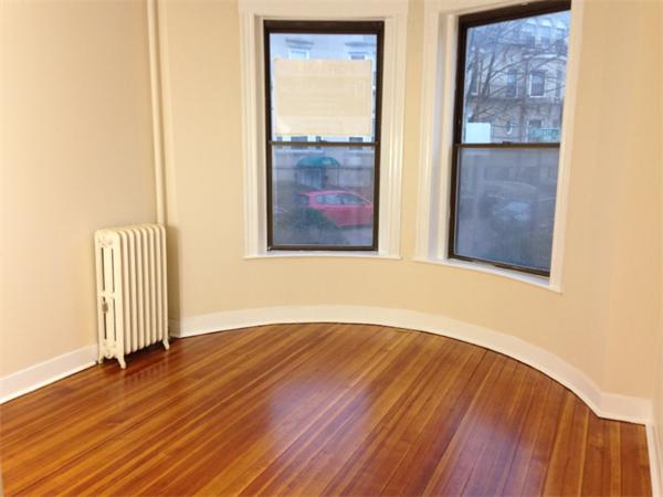 46 Orkney Road, Unit 1 Boston, MA 02135 - Photo 4 of 12 an empty room with wooden floor and windows
