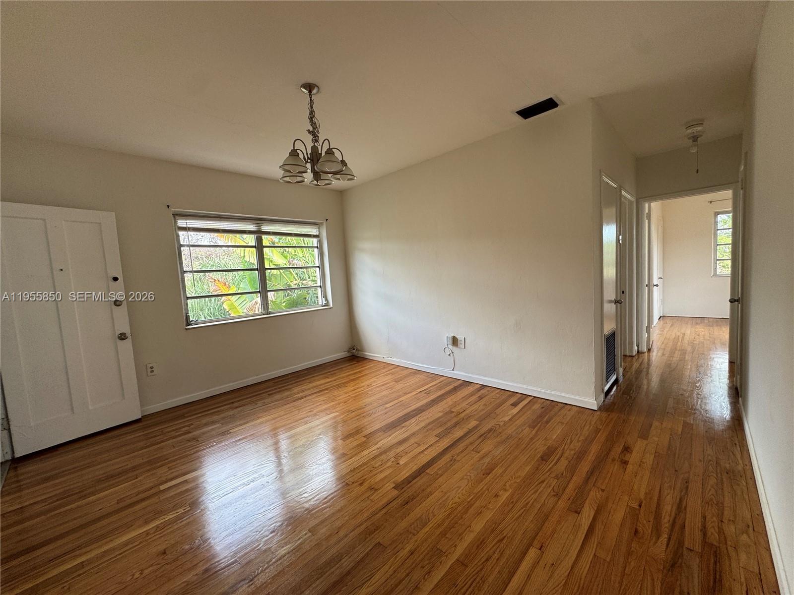 1431 Southwest 37th Avenue, Unit 4 Miami, FL 33145 - Photo 15 of 19 a view of an empty room with wooden floor and a window