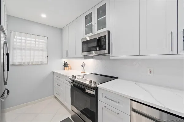 a kitchen with stainless steel appliances granite countertop a sink and a stove