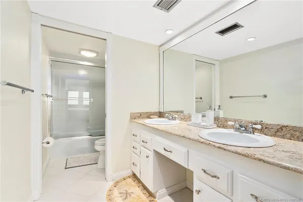 a bathroom with a granite countertop sink mirror and double