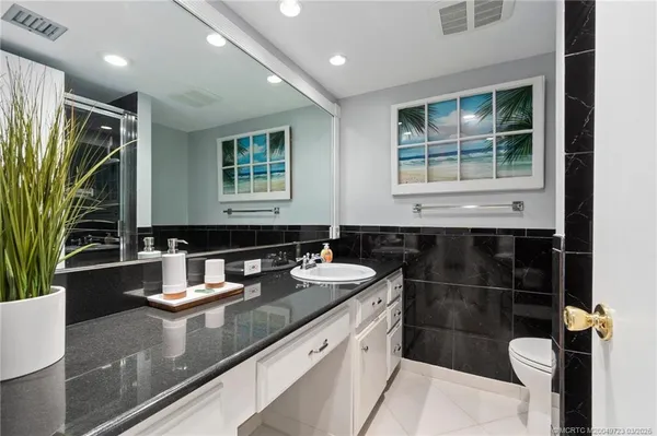 a bathroom with a sink a toilet and a mirror