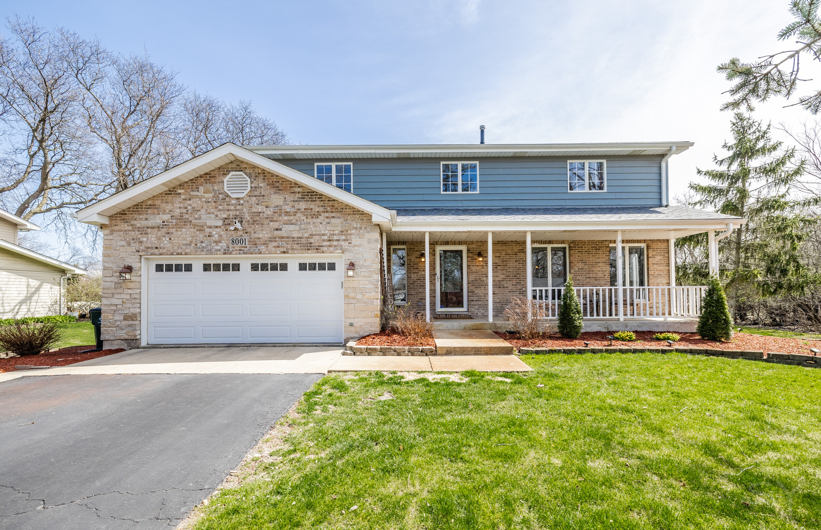 a front view of a house with a yard and trees