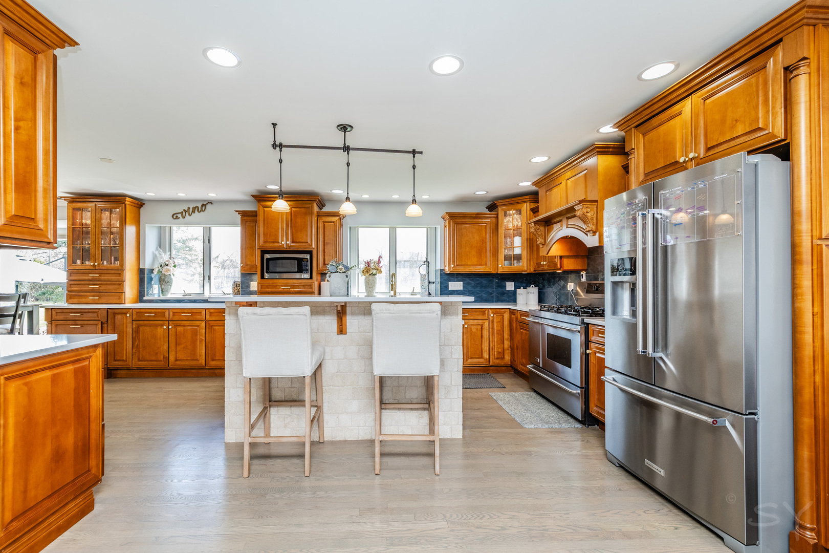 8001 William Drive Willowbrook, IL 60527 - Photo 7 of 73 a kitchen with stainless steel appliances granite countertop a refrigerator a oven a sink a dining table and chairs with wooden floor