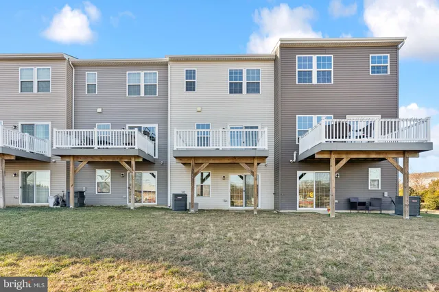 a view of a white house with large windows and a yard
