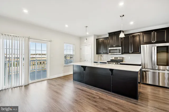 a large kitchen with stainless steel appliances and wooden cabinets