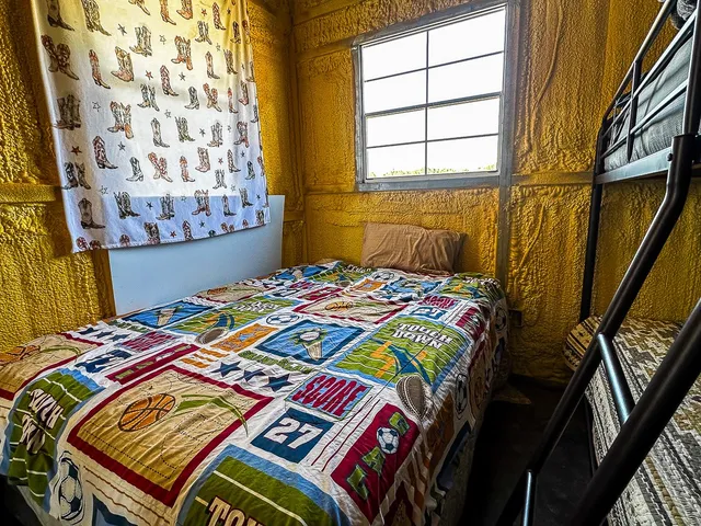 a bedroom with bed and wooden floor