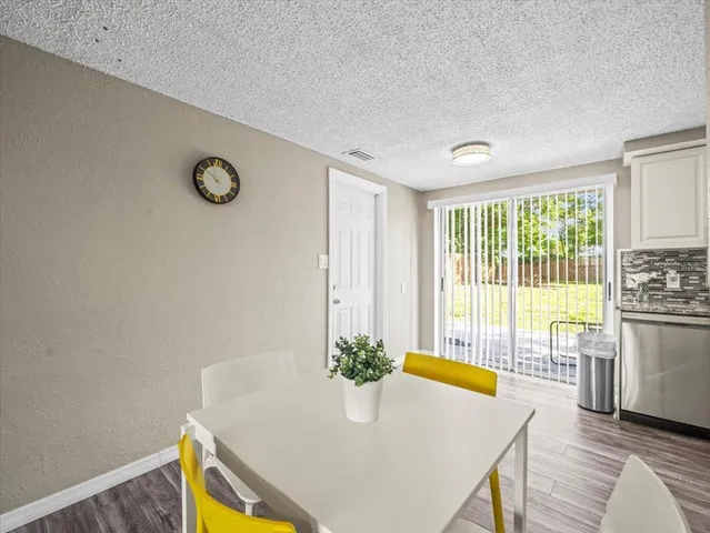 a view of a dining room with furniture a chandelier and wooden floor