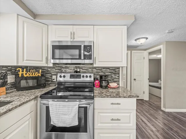 a kitchen with stainless steel appliances granite countertop a stove and a microwave