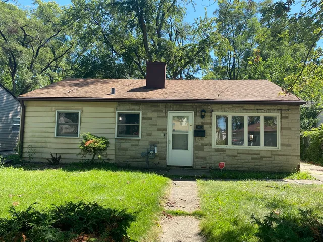 a front view of a house with a yard and garden