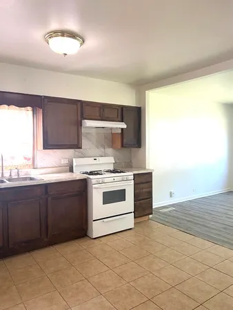 a kitchen with a stove sink and cabinets