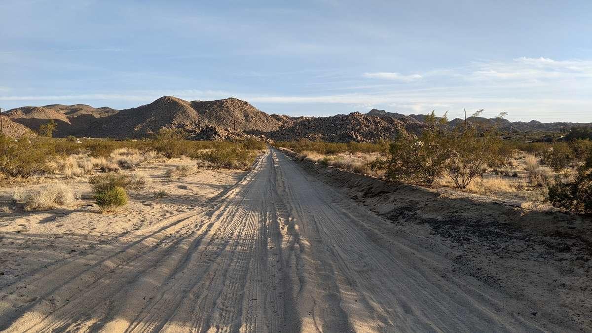 6742 Mile Square Road Joshua Tree, CA 92252 - Photo 7 of 13 a view of mountain with wooden floor and a floor to ceiling window