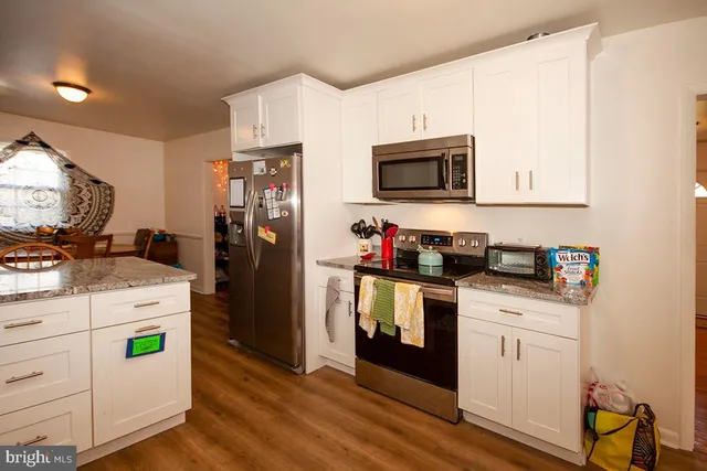 a kitchen with stainless steel appliances granite countertop a refrigerator stove and sink