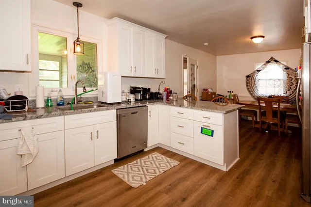 a kitchen with a stove a sink a dining table and chairs