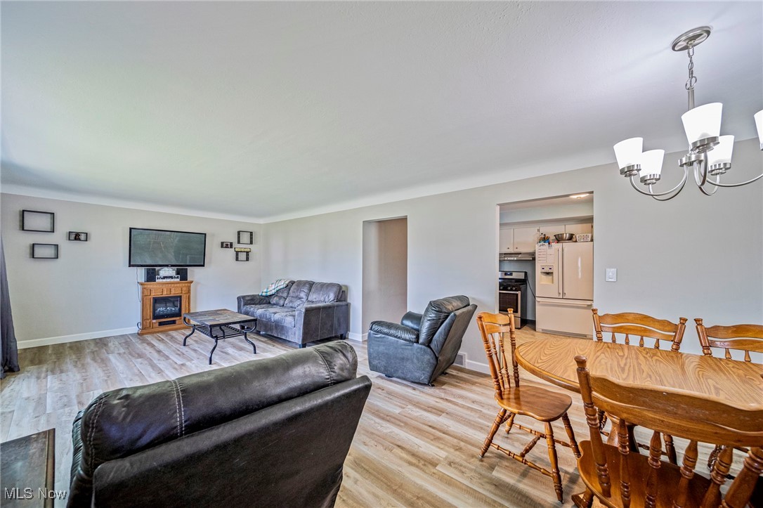Living area featuring light wood-style floors and a chandelier
