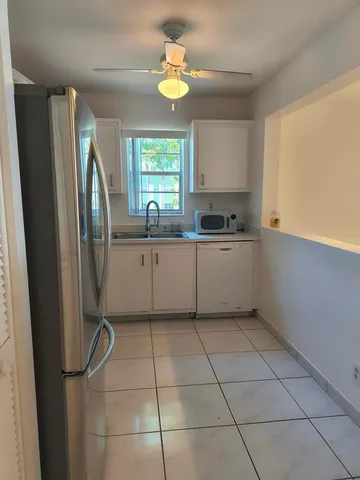 a kitchen with stainless steel appliances a sink a counter top space cabinets and a window