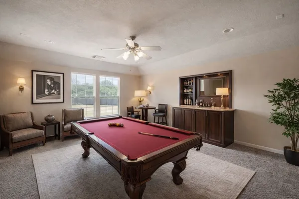 a room with furniture pool table flat screen tv and windows