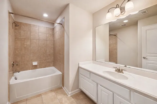 a bathroom with a tub a sink and mirror