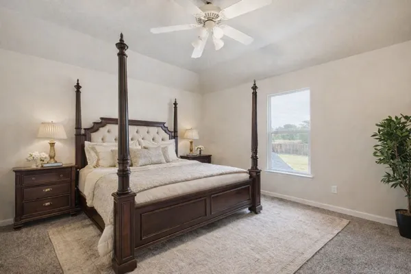 a bedroom with a bed table and window